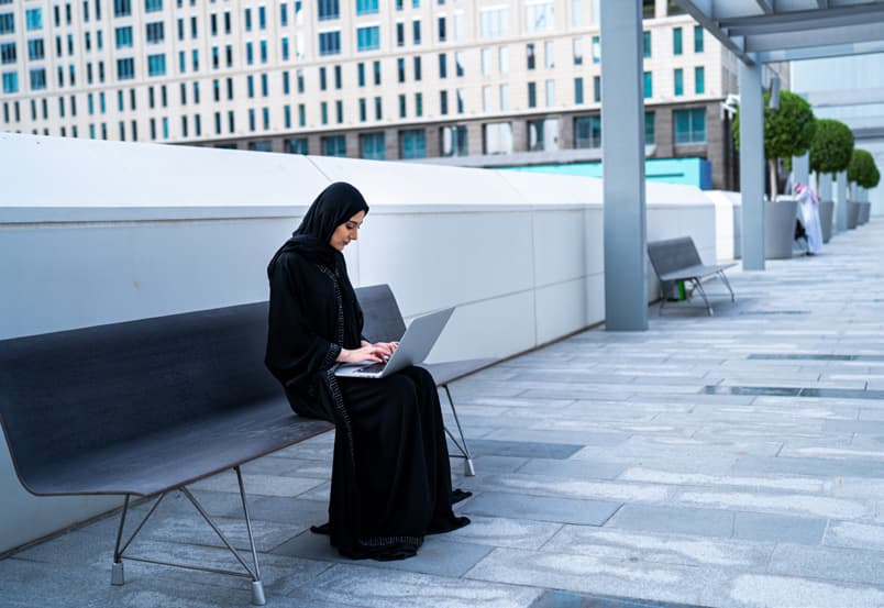 Working on a laptop in an outdoor plaza